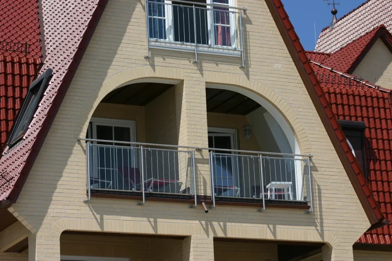 Bogenförmige Balkonöffnungen in der hellen Ziegelfassade des Strandhotels Grömitz